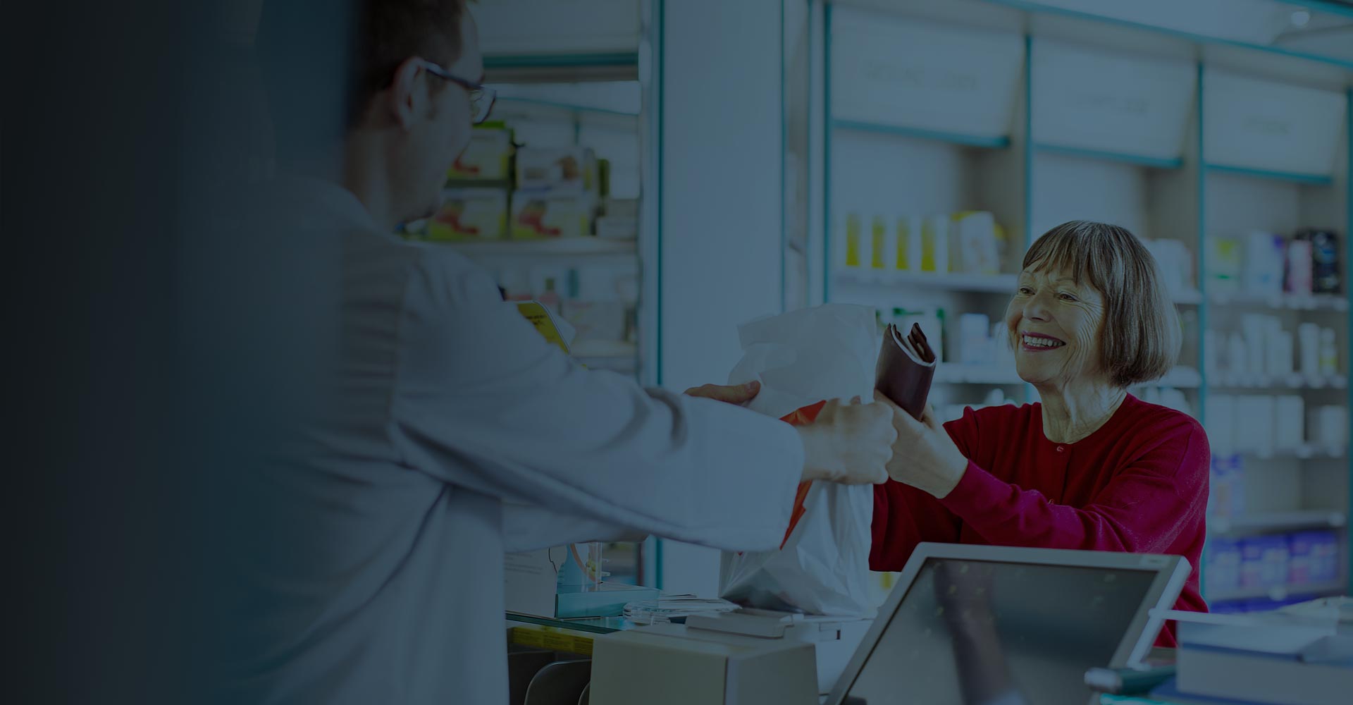 Pharmacist handing patient prescription over the counter