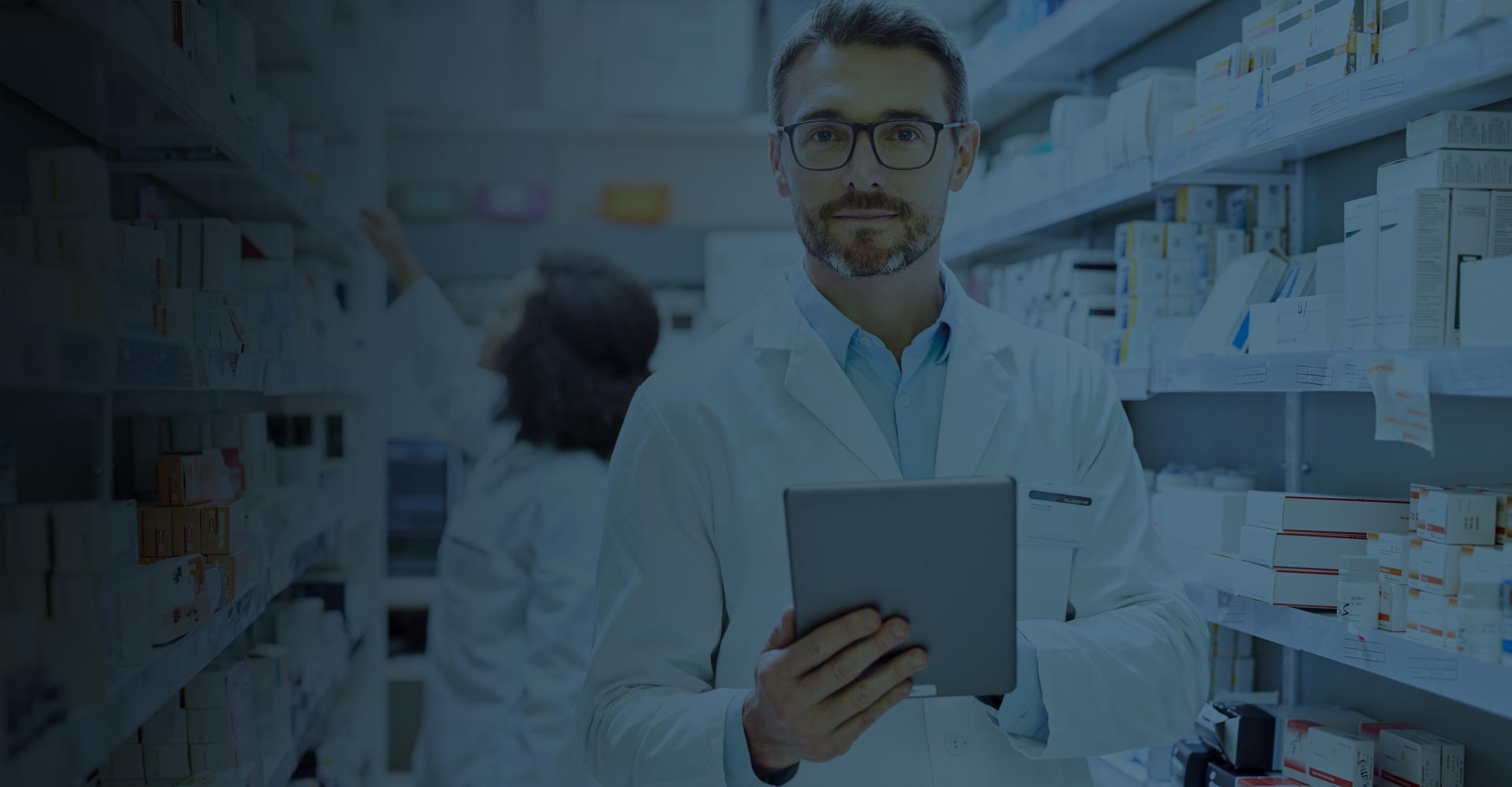 Pharmacist looking straight at the camera and holding a tablet
