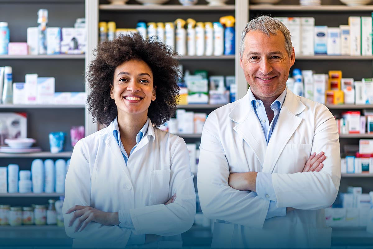 Two smiling pharmacists looking directly at the camera with arms folded across their chests